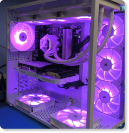 Gabinete de PC Gamer aquário na cor branca com iluminação LED interna nas cores violeta e rosa, destacando as memórias RAM instaladas e o water cooler com mangueiras organizadas.